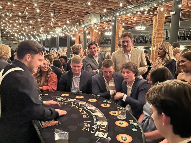 Mesa de blackjack de un casino de empresa bajo guirnaldas de luces en una nave de ladrillo