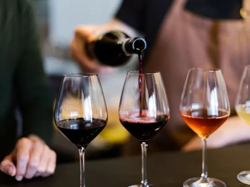 Servicio de tinto en tres copas alineadas para una cata de vinos de empresa
