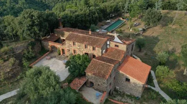 Casona de piedra rodeada de arbolado vista desde el aire