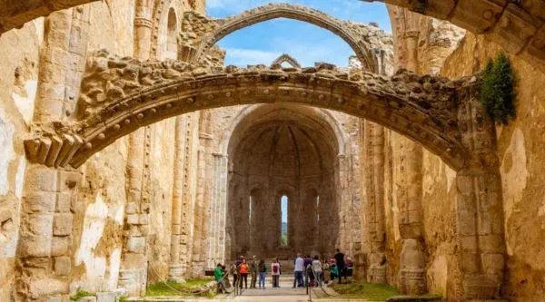 Arcos de piedra de la nave del monasterio con visitantes al fondo