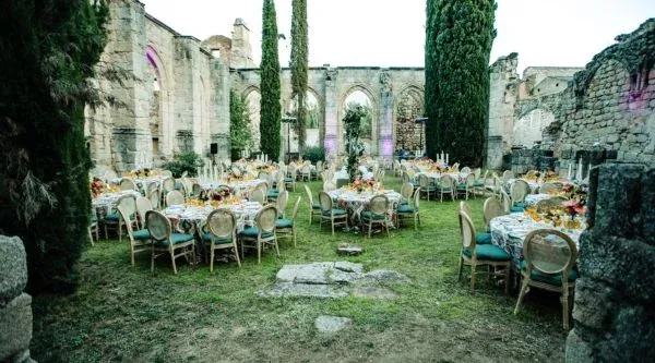 Mesas de banquete montadas en la nave en ruinas del monasterio, espacio para eventos de empresa